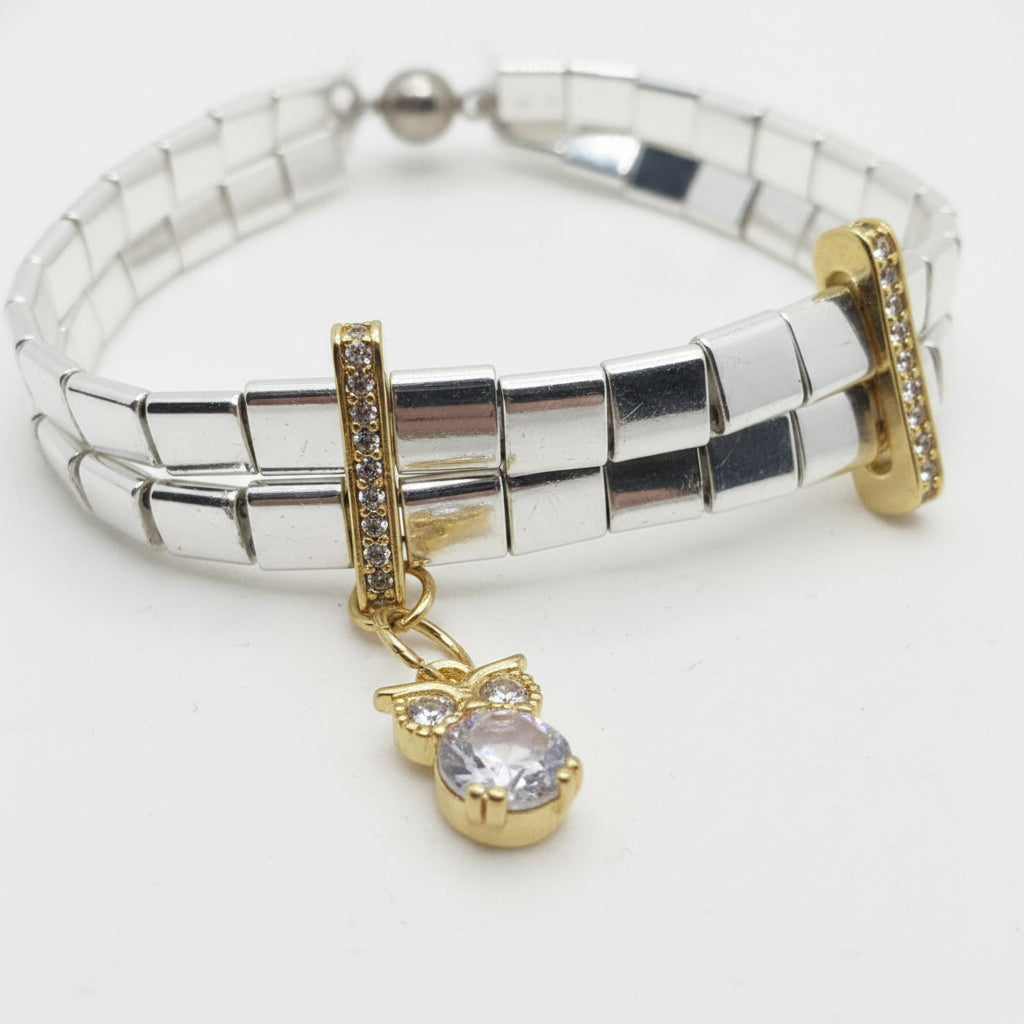 silver and gold tila bracelet featuring polished hematite beads and sparkling zircon details.